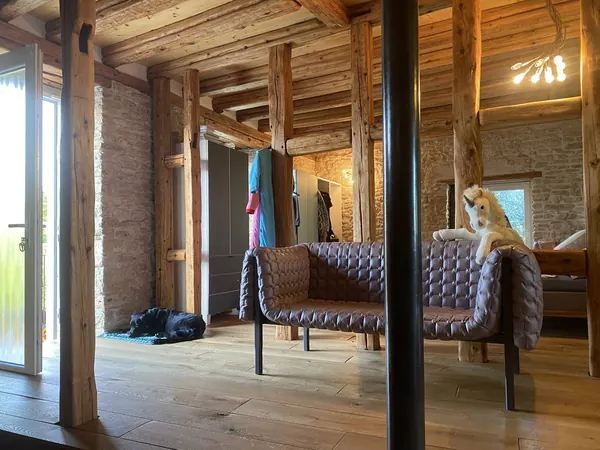 Ständer aus Rundholz — Holz und Bruchstein blieben sichtbar; der Boden ist neu.