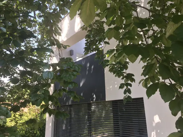 Ein dunkles Feld im hellen Putz — Der Sonnenschutz liegt in der Ansicht, nicht davor.